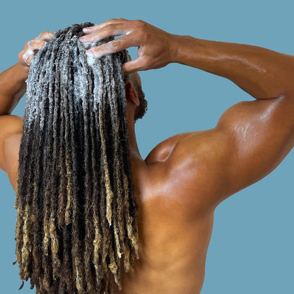 Man washing locs with rich-lather dread shampoo, removing buildup from locs and braids.